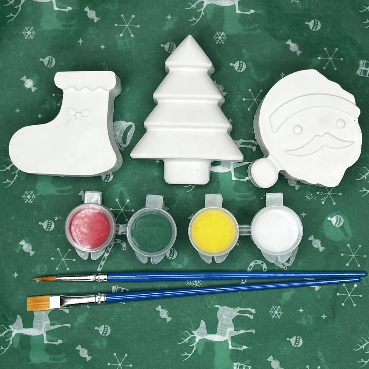 White plaster stocking, Christmas tree, and Santa with red, green, yellow, and white paint and two brushes